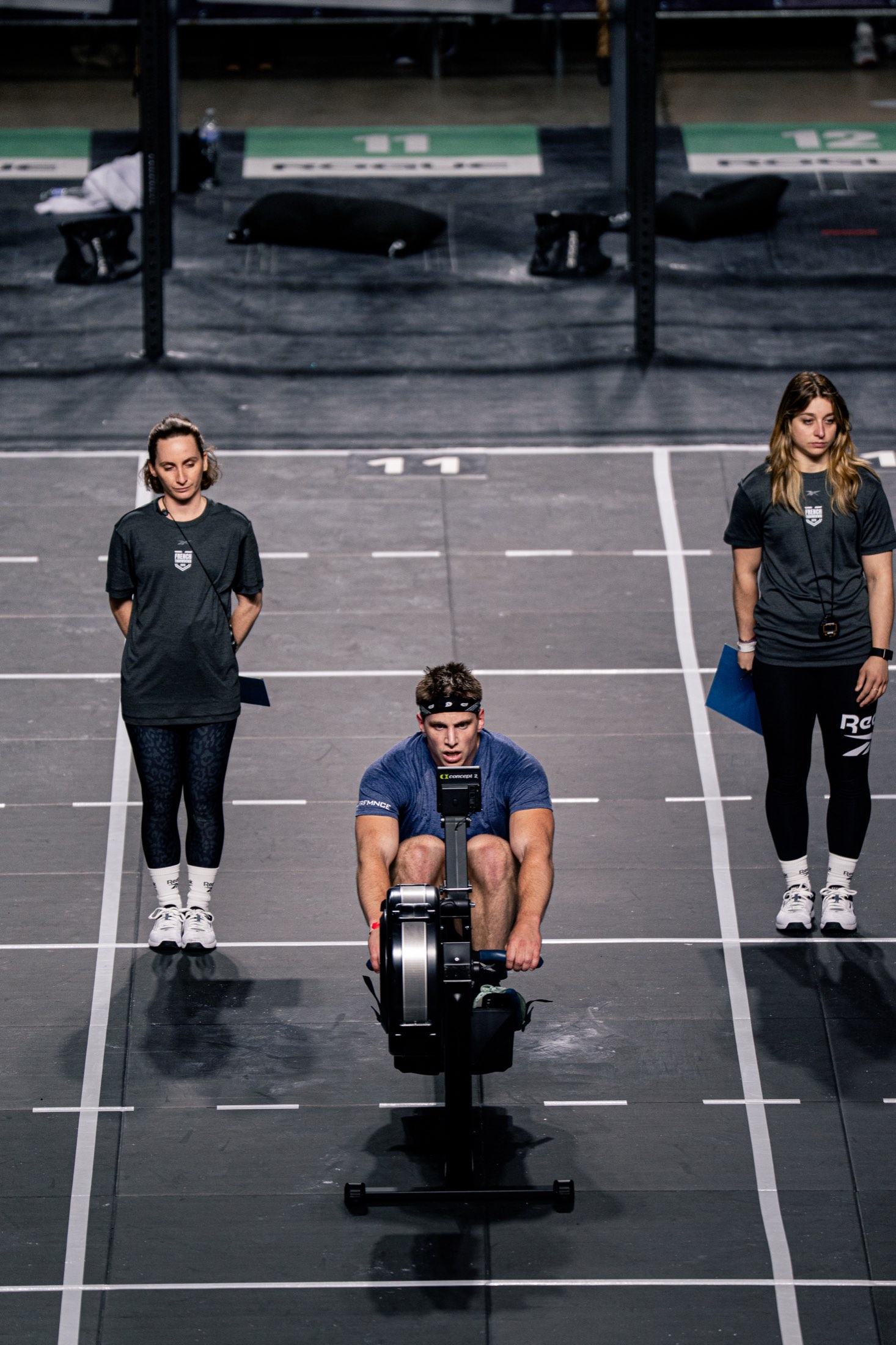 Kriger athlete on the rower with two judges watching