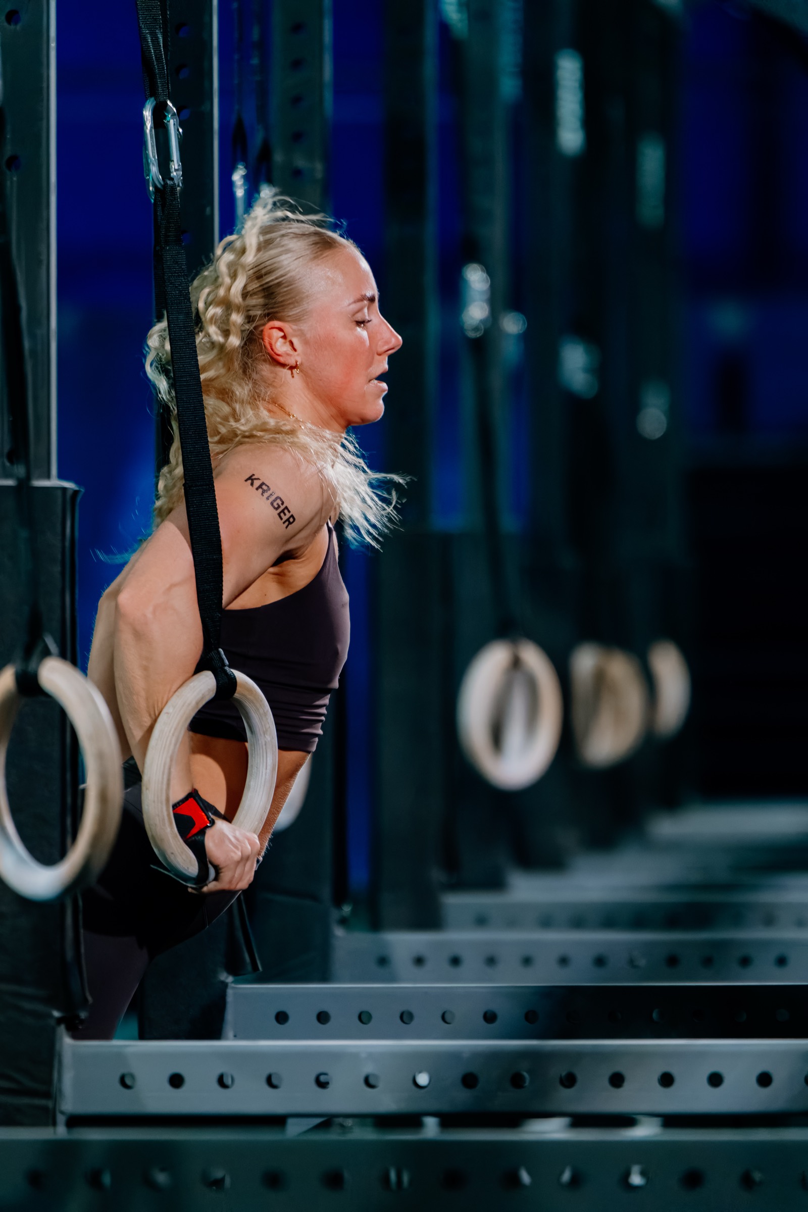 Kriger athlete in the bottom of a ring dip, mid muscle up transition